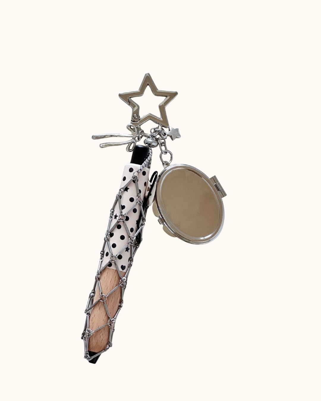 Kuura Macrame Journal Charm with Mirror in Star, a silver metal net pouch holding a pencil with an oval compact mirror and star clasp. Pen holder keychain