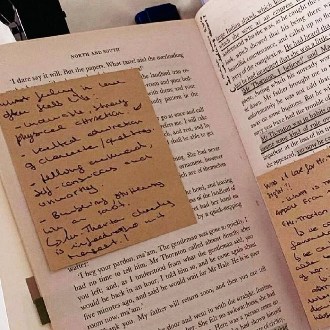 A close-up view of the classic novel North and South, featuring detailed handwritten reading notes on sticky notes placed directly over the text. This shows an aesthetic and practical journaling method for active reading and note-taking.