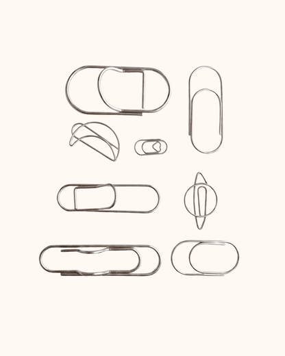 An overview of the Assorted Silver Wire Journal Clip Set, featuring 8 minimalist shapes including a delicate heart, a celestial planet, and wide pen loop designs. Perfect for marking planner pages or securing loose notes.
