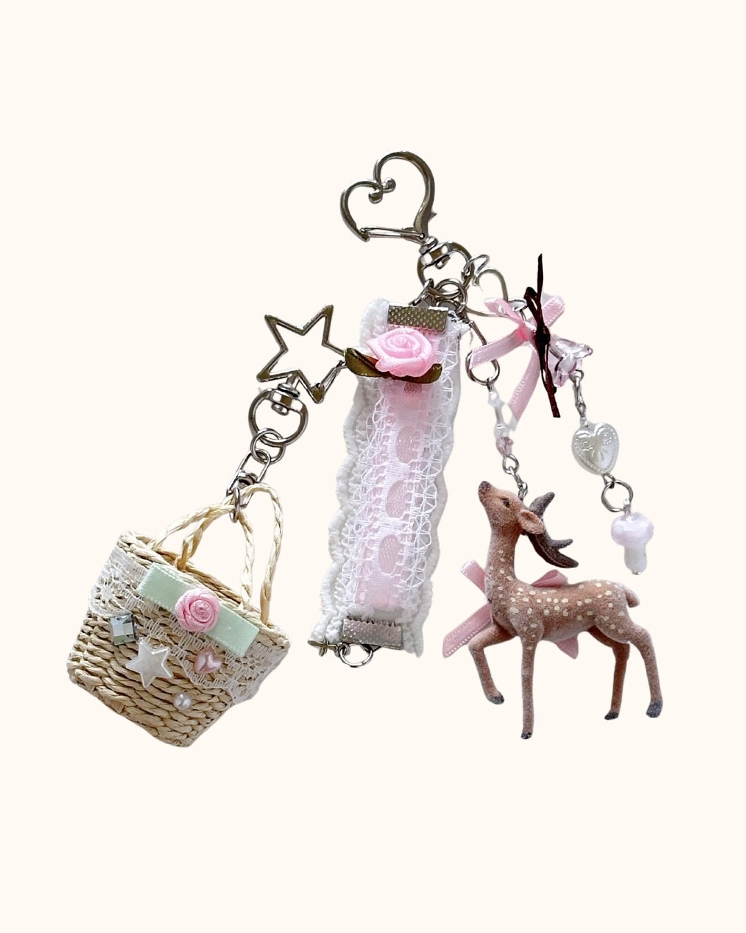 Kuura Little Meadow Charms Set of 2, a flocked deer charm and a lace-trimmed woven picnic basket charm on star and heart clasps. Cottagecore bag charm
