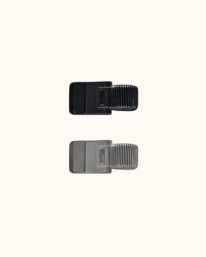 Kuura Minimalist Pen Loop in black and silver, two slim metal clip-on pen loops shown side by side. Minimalist stationery accessory for journal covers