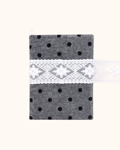 Kuura Polka Dot A5 & A6 Journal & Notebook Cover in Charcoal, heathered grey with black dots and a white lace band, front view. Travel journal cover