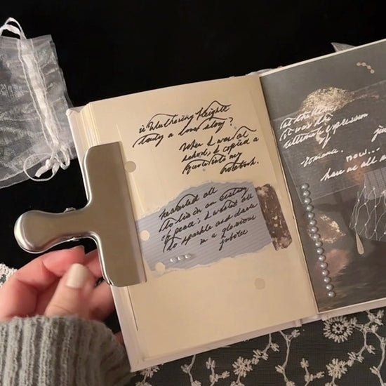 Kuura Silver journal clip shown holding a notebook page in place