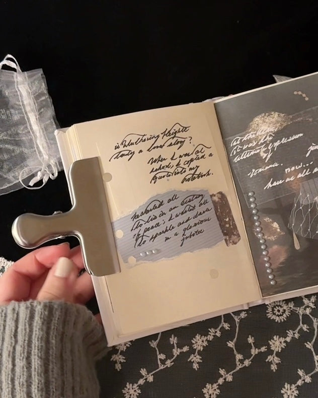 Kuura Silver journal clip shown holding a notebook page in place