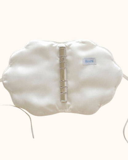 The handmade pearl white shell-shaped fabric journal cover, opened flat to reveal its intricate puffy quilted pattern and delicate ribbon tie closures. An artisan-made soft sleeve and seashell binder cover perfect for aesthetic bullet journaling, A6 planners like Midori